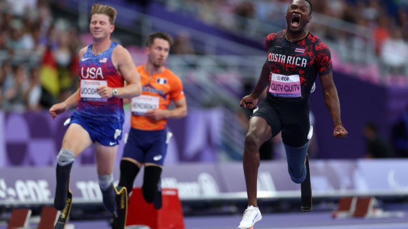 Three male athletes with prosthetic legs in a Para athletics race