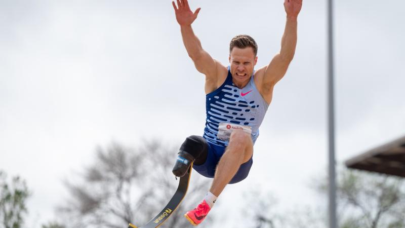 A man with a prosthetic leg competing in the long jump