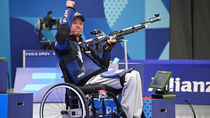 An athlete lifts his fist in air