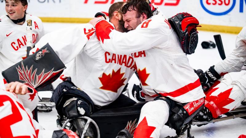 A group of Canadian Para ice hockey players celebrating on ice