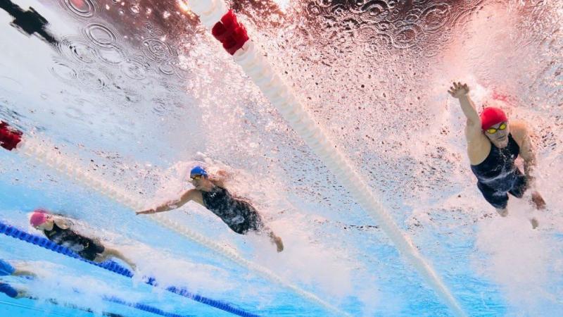 An underwater photo of three female Para swimmers