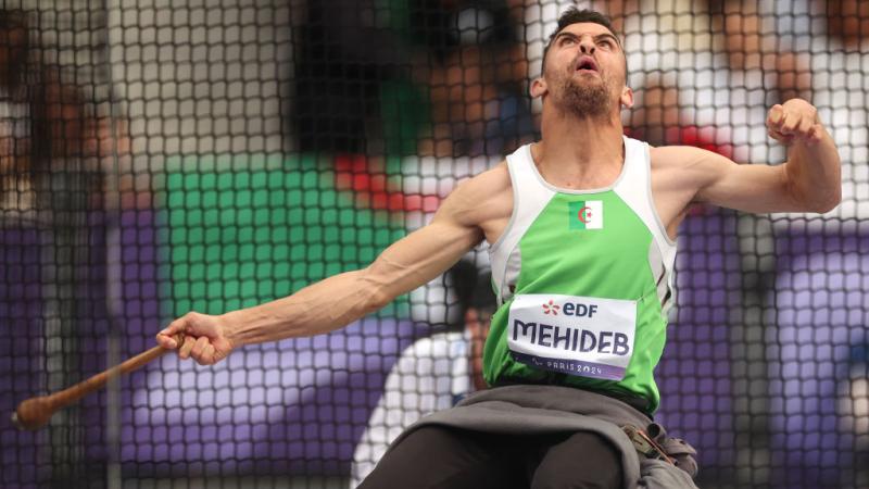 A male athlete competing in the club throw 