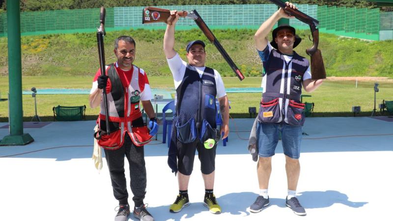 Three Para trop shooters standing with their shotguns after a competition