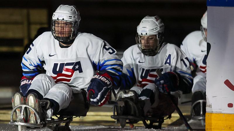 Three USA female Para ice hockey players entering the ice rink