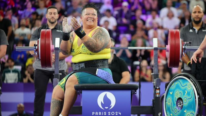 A female powerlifter clapping hands on the bench press at Paris 2024
