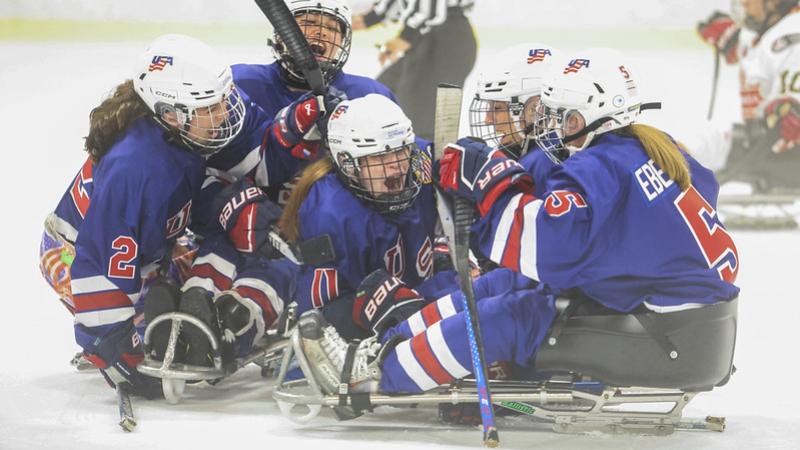 USA women&#039;s Para ice hockey team celebrating a goal on ice