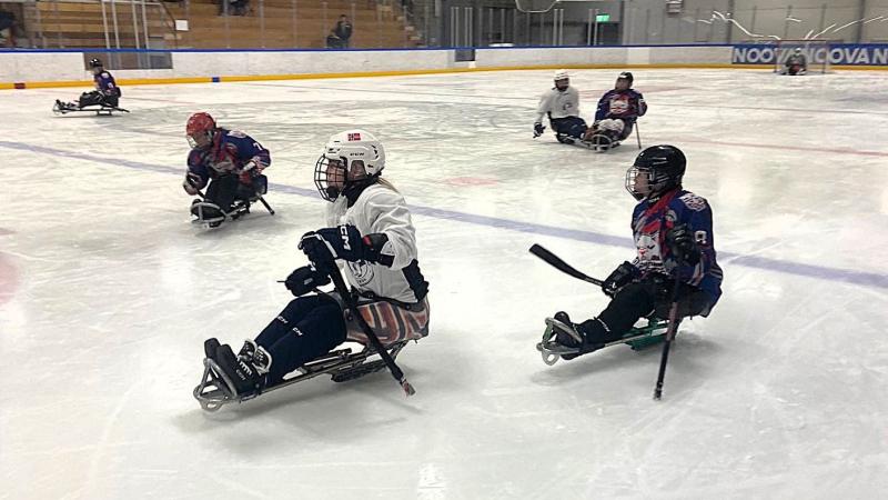 Six female Para ice hockey players in a game