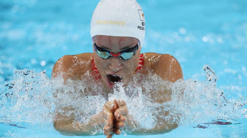 A female athlete with blackened goggles swimming breaststroke