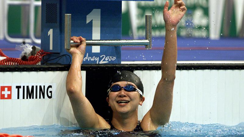 A female swimmer waving from the swimming pool at the Sydney 2000 Paralympic Games