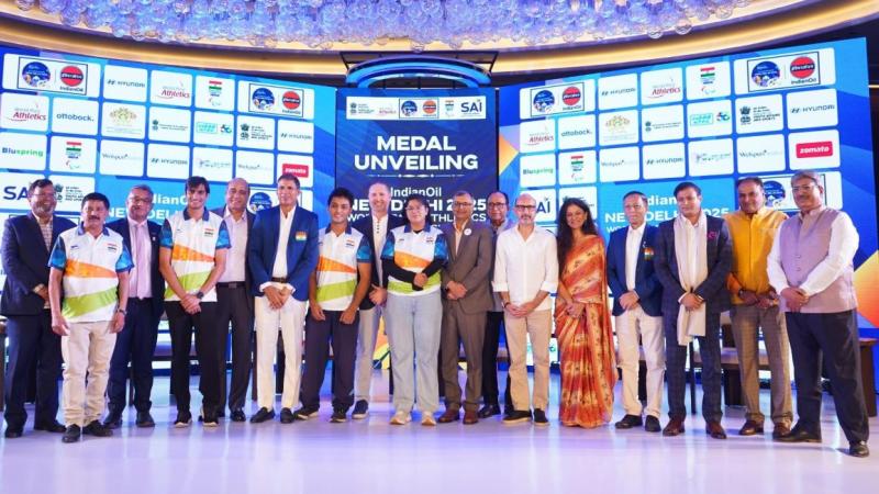A group of people on a stage showing medals
