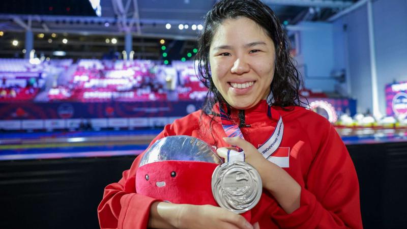 An athlete shows her medal 