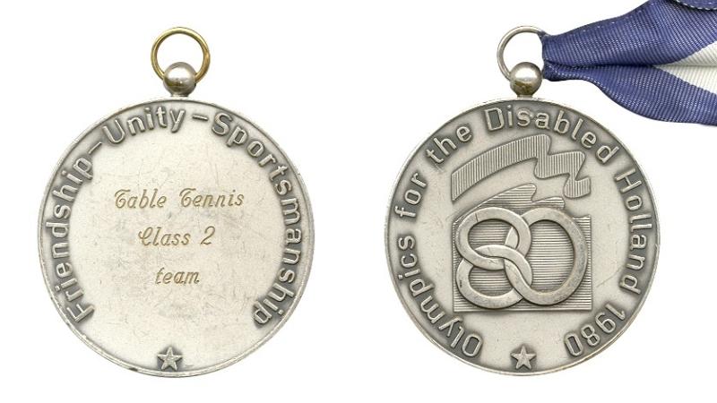 The back and front of the silver medals from the Arnhem 1980 Paralympic games.