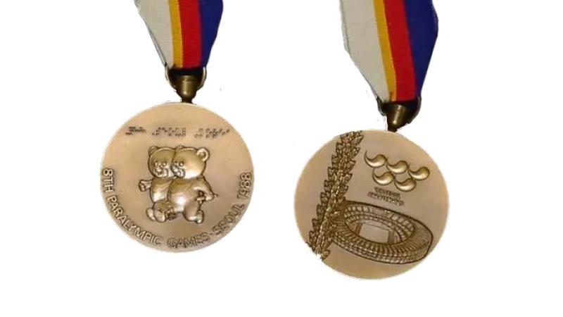 The back and front of the Seoul 1988 Paralympic medal.