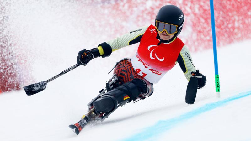 A female sit-skiing athlete is in action