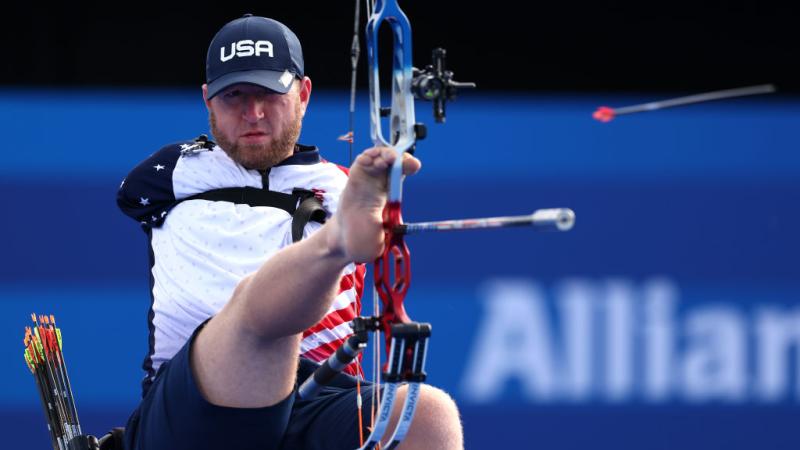 A Para archery athlete aims the bow using his right feet