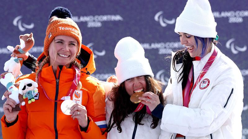 Three female athletes are celebrating on the podium