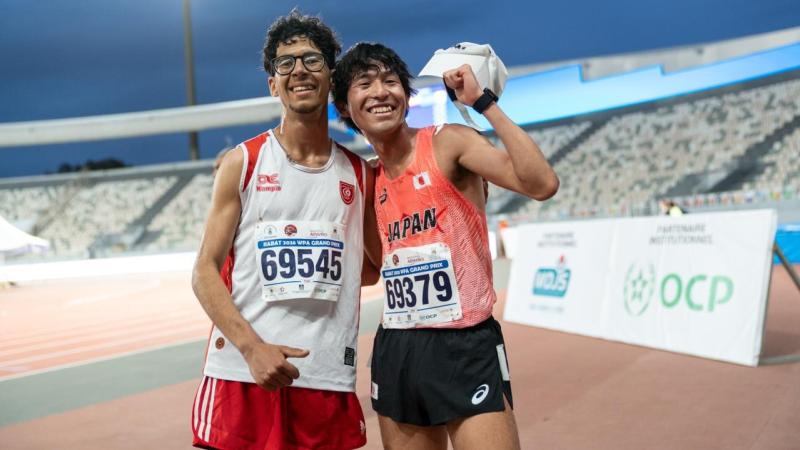 Two athletes celebrate in joy in an athletics track