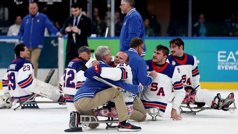 A group of Team USA Para ice hockey players celebrating on ice