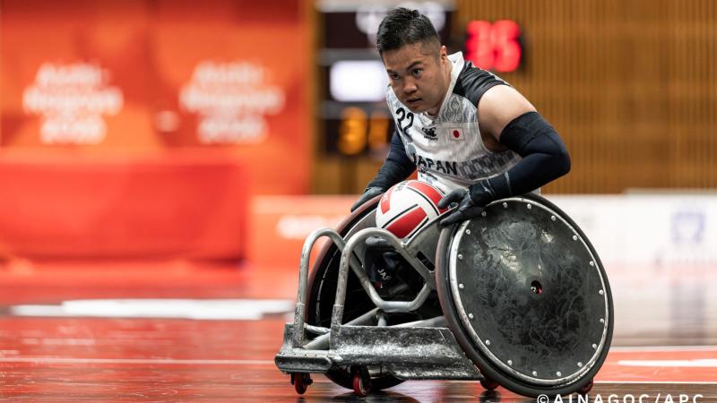A male athlete is carrying the ball