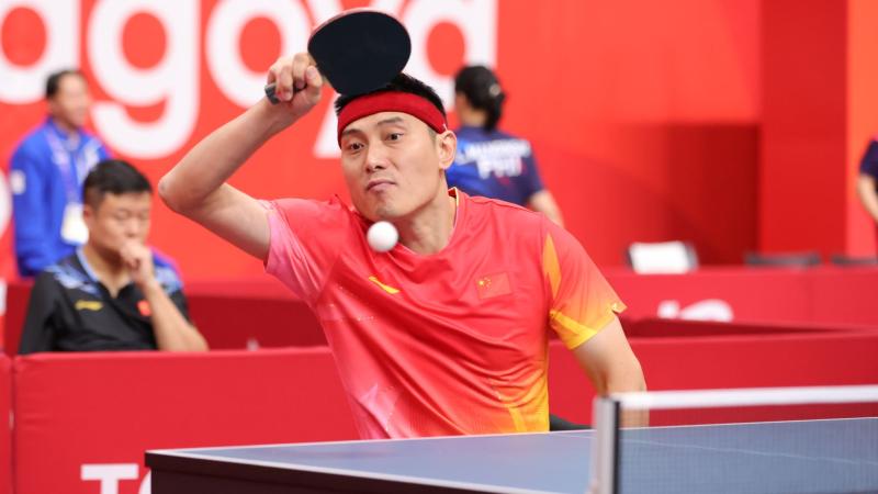 A male Para table tennis player is returning a shot