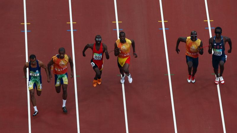 General view of athletes competing in the Men's 100m-T11
