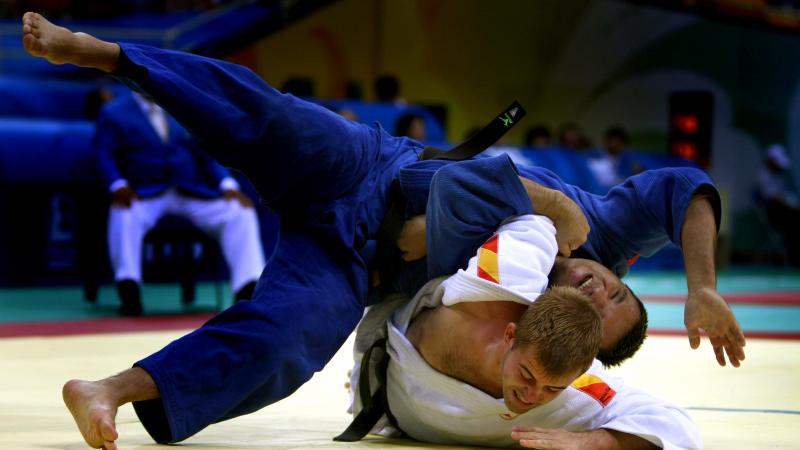 Two judo athletes fighting on the ground.