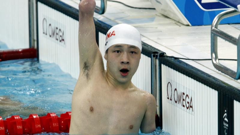 Qing Xu celebrating his win in the pool.