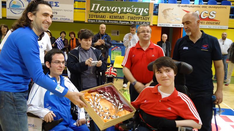 Man handing a Boccia player some flowers