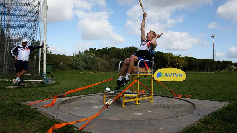 A picture of an athlete sit down throwing an object