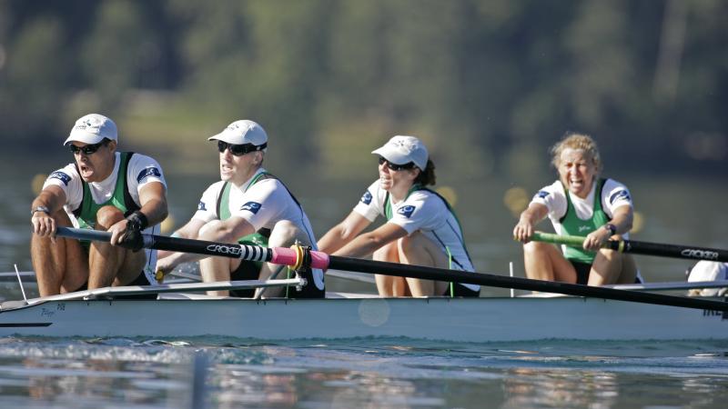 A picture of four people rowing 