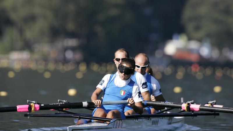 A picture of four italian people rowing.