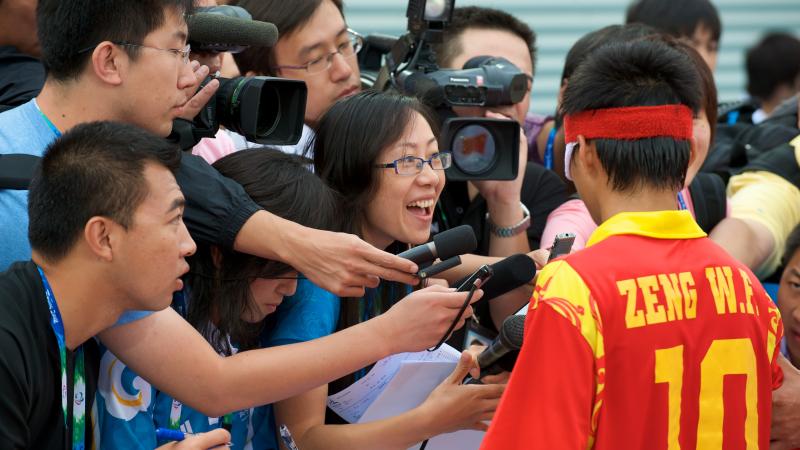 A picture of plenty of journalists trying to interview a 5-a-side football player.