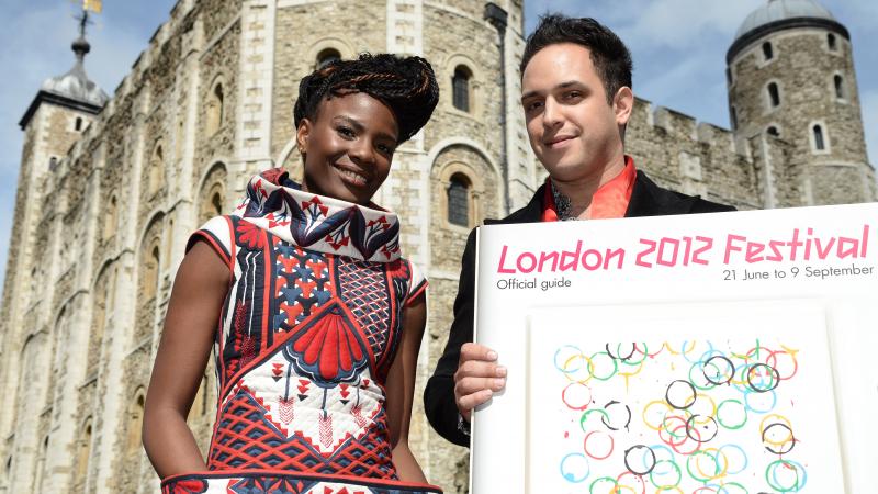 A picture of 2 standing people in front of a castle showing the London 2012 festival Official Guide.