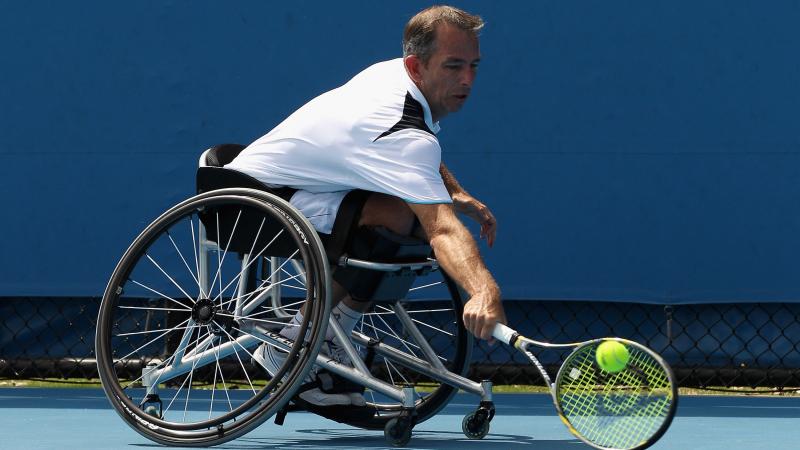 A picture of a man in a wheelchair playing tennis.