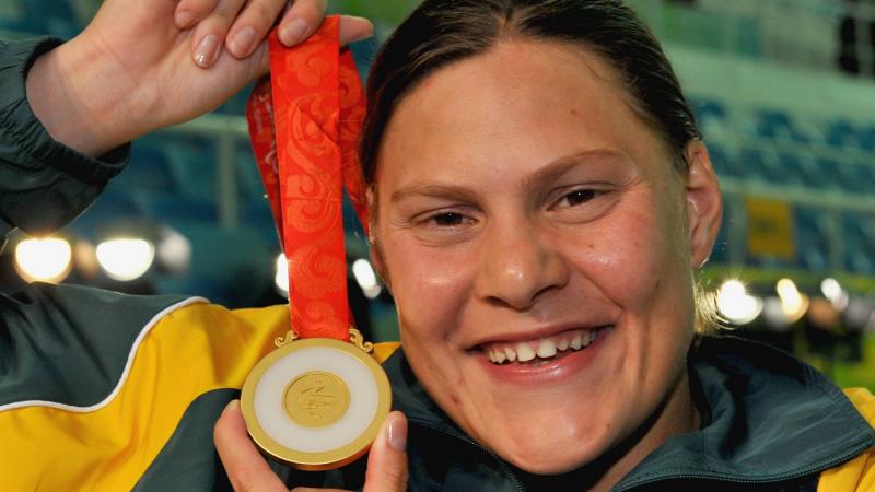 A picture of a girl showing a gold medal after her victory