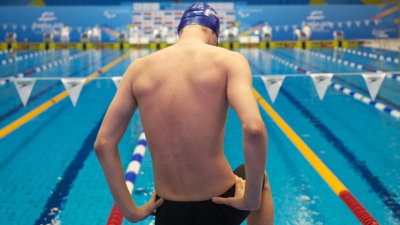 A picture of a man standing in front of a pool