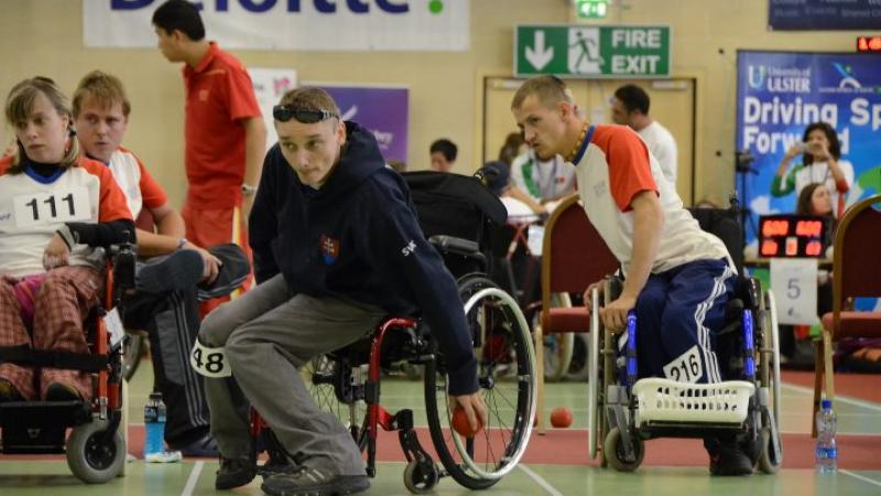 A picture of a man in a wheelchair throwing a small ball