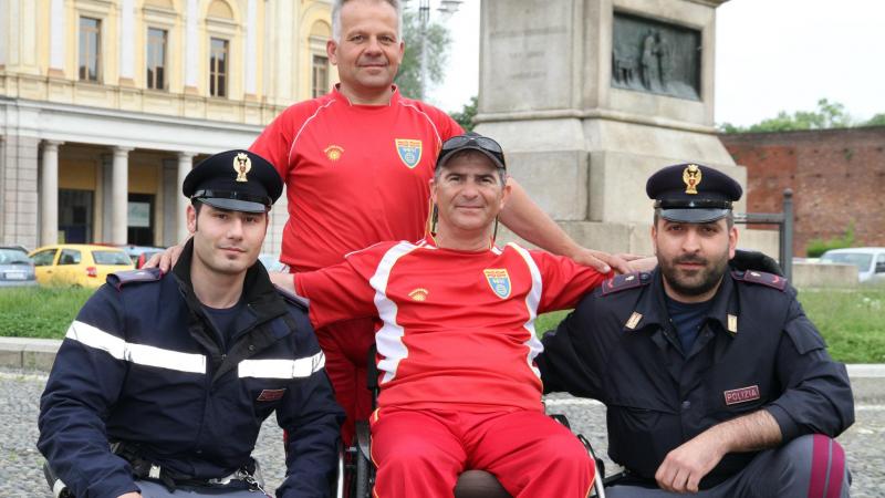 A picture of a man in a wheelchair posing between 2 policemen
