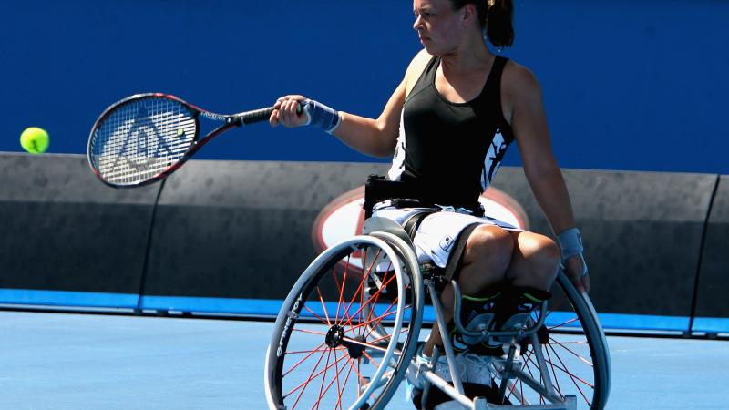 A picture of a girl in a wheelchair playing tennis