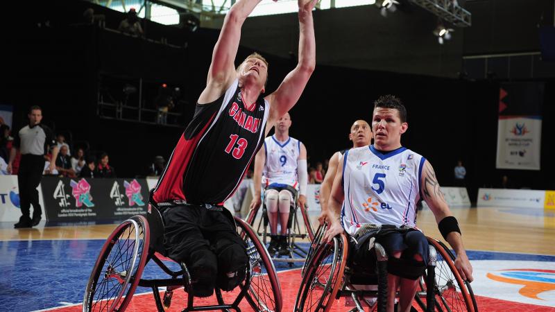 A picture of a man in a wheelchair shooting a ball in a Wheelchair Basketball match