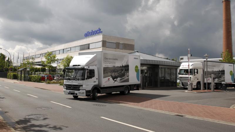 A picture of two trucks leaving a firm