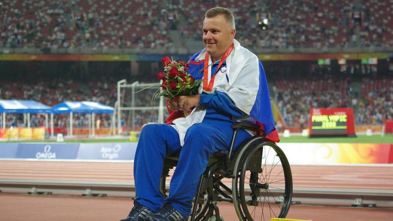 A picture of a man in a wheelchair during a medal ceremony