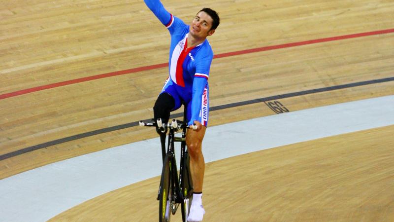 A picture of a man celebrating his victory on a bike