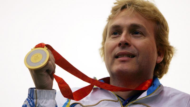 A picture of man showing his gold medal