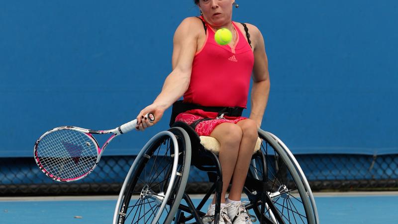 A picture of a woman in wheelchair playing tennis