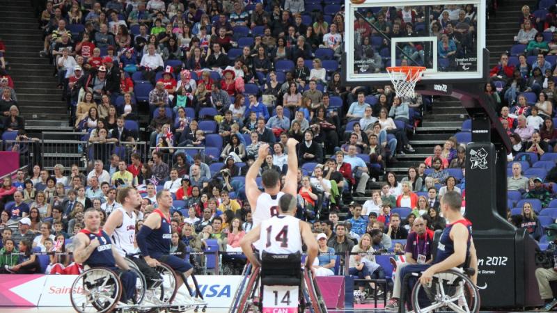 A picture of a man in a wheelchair shooting during a basketball match