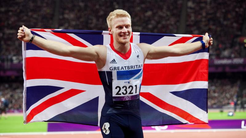 A picture of man celebrating his victory with a British Flag