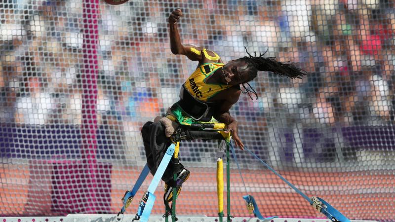 A picture of a man sit down and throwing a discus