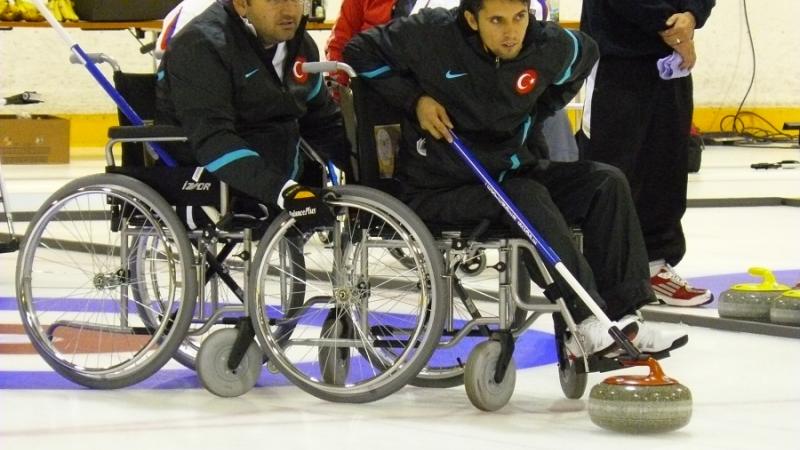 A picture of a man in wheelchair playing curling