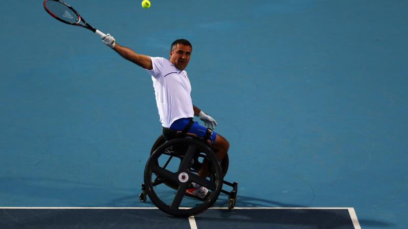 A picture of a man in a wheelchair playing tennis